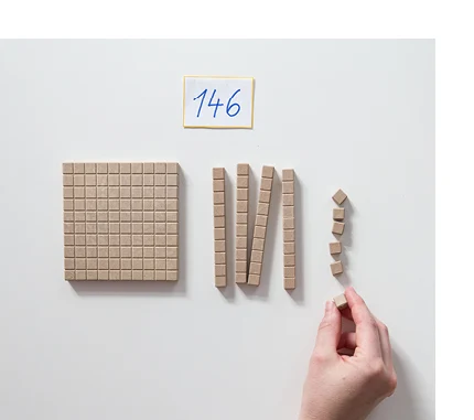 Eine Hand legt mit Hilfe der einzelnen Würfeln, Stangen und Platten eine vorgegebene Zahl.