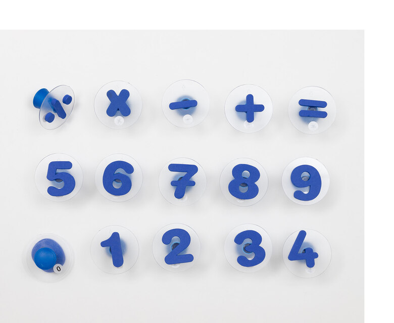 Auf einer Unterlage liegen dunkelblaue Plastikzahlen von eins bis neun in Form eines Stempels. Darüber liegen die Rechenzeichen geteilt durch, mal, minus, plus und istgleich. Ebenfalls in Form eines Stempels.